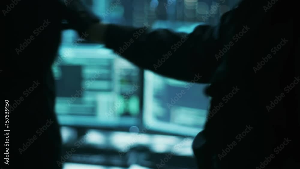 Poster close-up of hacker getting handcuffed at his hidden place by cybersecurity police officer. shot on r