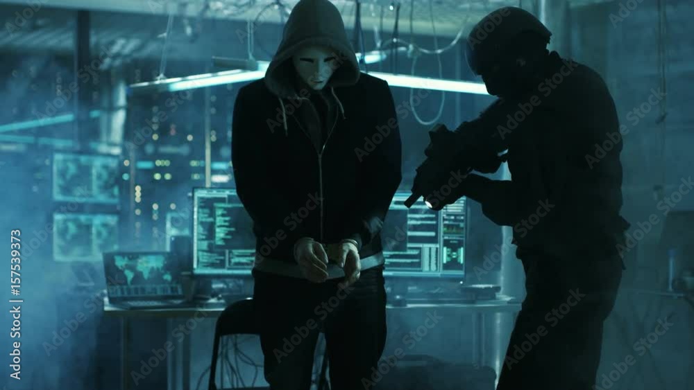 Leinwandbilder masked hacker wearing handcuffs is guarded by fully armed special forces soldier. they're in hacker'