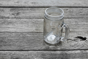 Empty glass jar for drinks on rustic wood