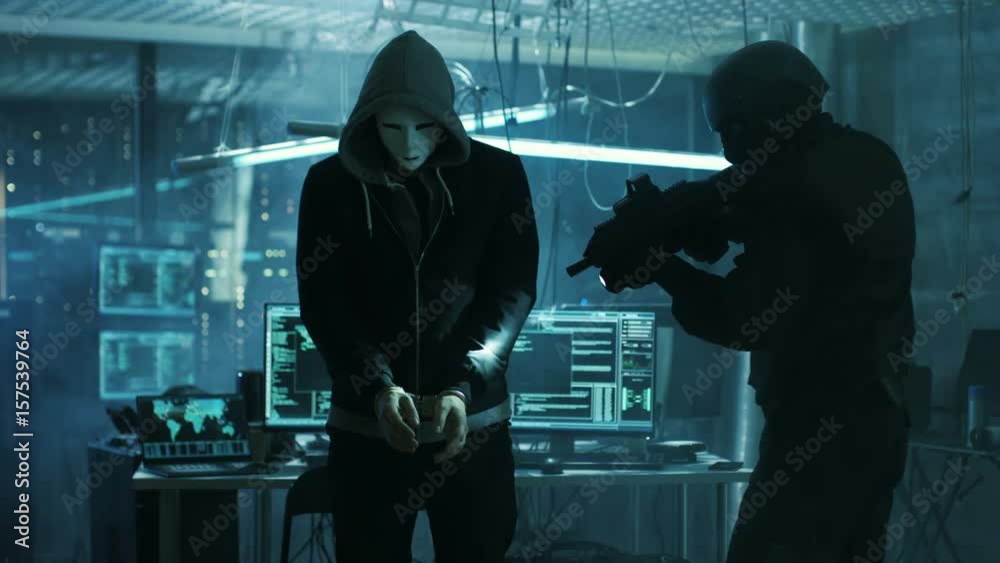 Aufkleber Masked Hacker Wearing Handcuffs is Guarded by Fully Armed Special Forces Soldier.  They're in Hacker's Hideout Basement with Multiple Operating Displays. Shot on RED EPIC-W 8K Helium Cinema Camera.