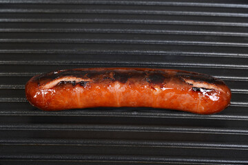 closeup of sausage cooking on a grill