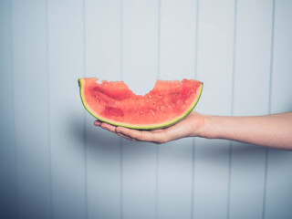 Female hand with slice of watermelon