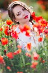 Beautiful woman in field of poppy flowers, spring time