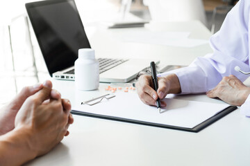 Healthcare and Medical concept, patient listening intently to a female doctor explaining patient symptoms or asking a question as they discuss paperwork together in a consultation