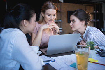 young casual businesswomen working on laptop at office together