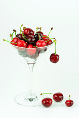 Kirschen im Cocktailglas vor weißem Hintergrund