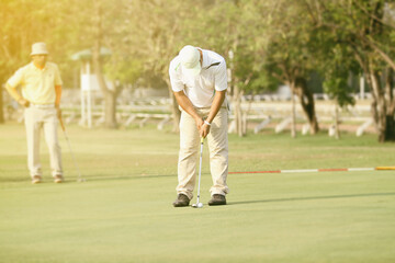 Obraz premium Asian golfers hit sweeping and keep golf course in the summer for relax time,soft focus and blurry