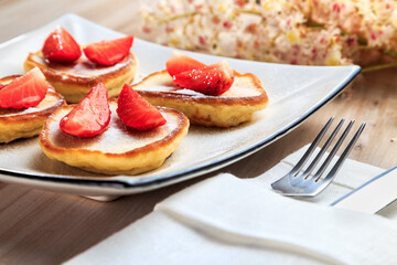 pancakes with strawberries on a beautiful plate stand on the table