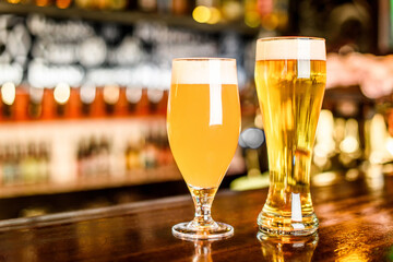A two Glass of light beer on a pub with bokeh background