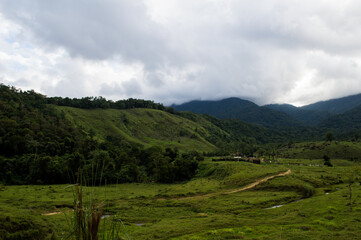 beautiful scenery of farm with clouds on the montains