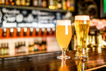 A two Glass of light beer on a pub with bokeh background