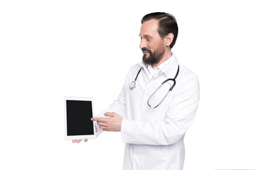 bearded doctor in white coat with stethoscope presenting digital tablet with blank screen isolated on white