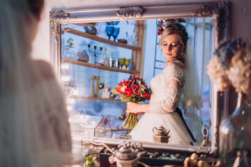beautiful bride looks in the mirror