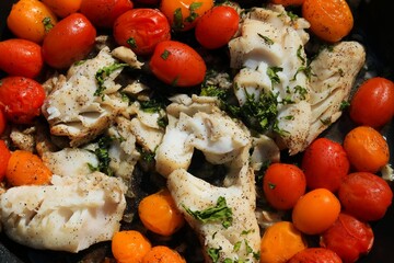 fish with tomatoes and herbs close up