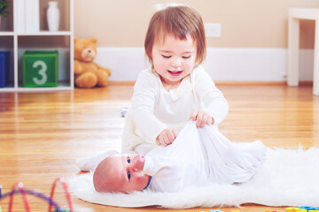 Fototapeta premium Happy toddler girl with her newborn sister