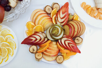 Sliced fruits served on white plate on dinner table