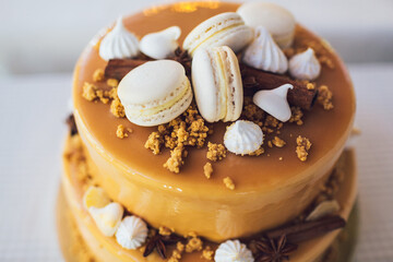 Tired cake decorated with white macaroons and yellow cream