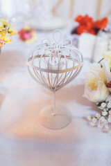 Little decorative cage stands on white dinner table