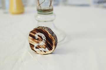 Number two written on wooden board stands on dinner table