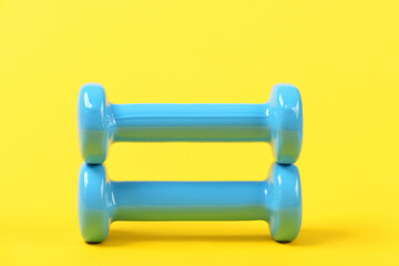 training concept with barbell or dumbbells on yellow