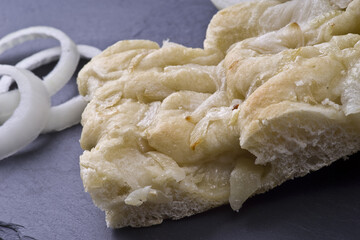 white pizza with onions on the slate stone background
