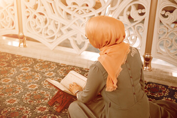 woman praying in the mosque and reading the Quran