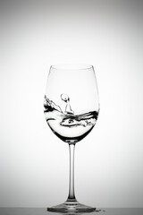 Water splashing in a wine glass on a gradient background
