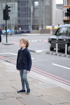 The child is in a city street. London, Great Britain.