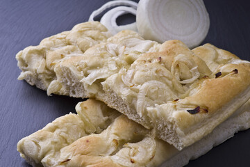white pizza with onions on the slate stone background