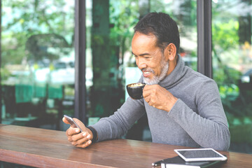 Portrait Smiling Attractive mature man with white stylish short beard using smartphone. Serving...