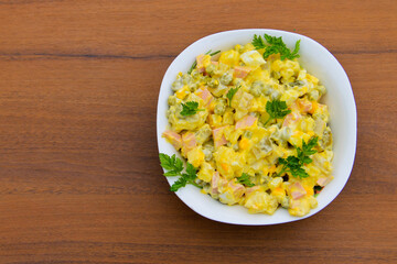 Russian traditional salad olivier on wooden table