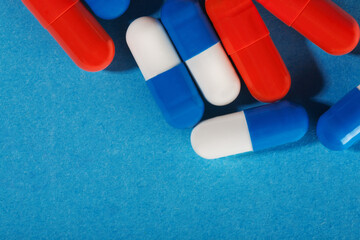Medical pills white-blue and red on a bright background