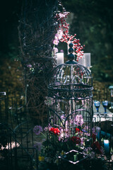 Decorative lanterns and vases with candles in dark red colors stand on green lawn and ground. Advertising concept.