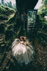 Woman lying under a tree like in fairytale. Advertising concept.