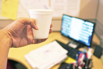 Close up of a girl hands relaxing watching media content on line in a red laptop on line and holding a coffee cup in a table at home