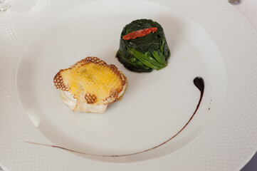 Steamed sea bass wrapped in potatoes with herbs and vegetables