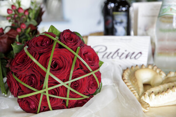 Bouquet da Sposa di rose rosse e foglie verdi su tavolo allestito