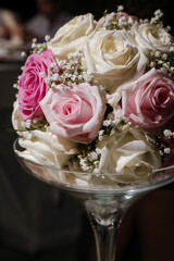 bellissima composizione floreale di rose di vario tipo dentro bicchiere di vetro