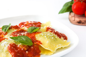Ravioli with tomato sauce and basil isolated on white background
