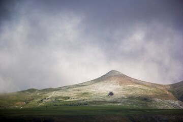 Fototapeta premium Горный пейзаж, красивый вид на зеленые холмы, пасмурное небо в облаках, панорама горной местности, дикая природа Северного Кавказа