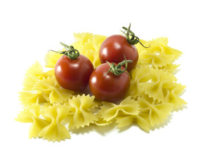 Cherry tomatoes with dry Italian pasta on a white background.