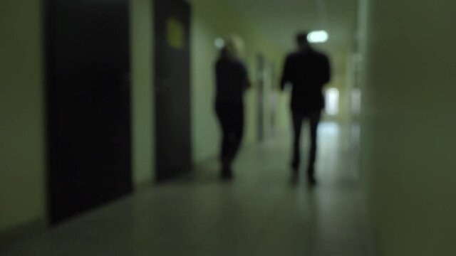 Silhouettes of people pass through the dark corridor. Incognito .Espionage.