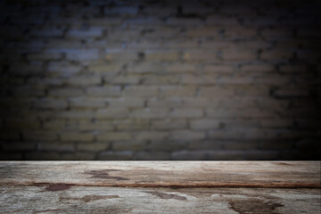Selected focus empty old wooden table and wall texture or old black brick wall blur background...