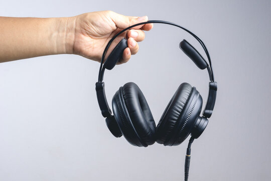Hand holding full ear or studio headphone