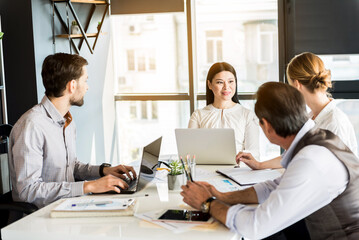 Obraz premium Confident cheerful employees sharing ideas in office