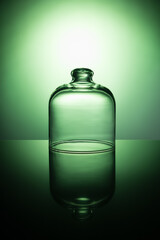Empty glass jar on a light green background