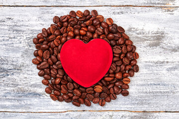 Red heart on coffee beans. Coffee grain on wooden background. Made with love.