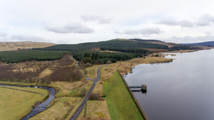 Naklejka premium Aerial image of reservoir with country road and forest plantations.