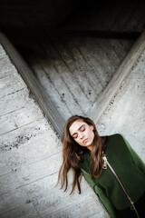 Pretty young woman standing and posing outdoors. Eyes closed.