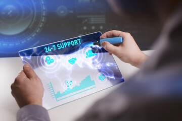 Business, Technology, Internet and network concept. Young businessman working on a virtual screen of the future and sees the inscription: 24-7 Support